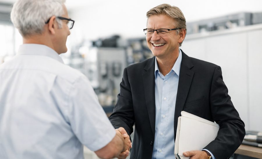 Two STASTO employees shaking hands on the shop floor